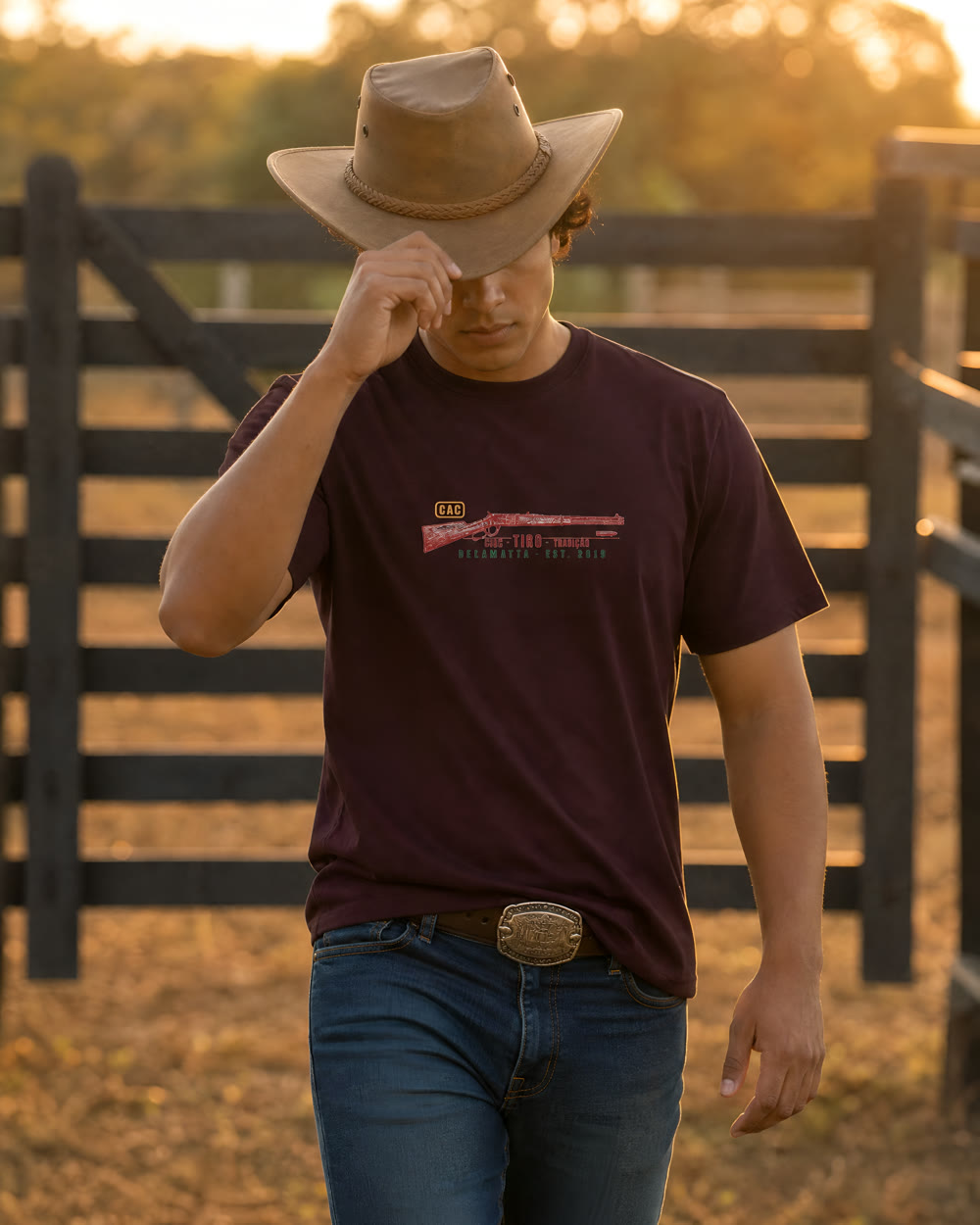 Homem de chapéu vestindo a camiseta bordô Caça Tiro Rifle no campo